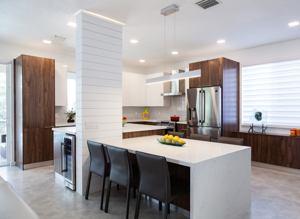 マイアミにある高級な中くらいなコンテンポラリースタイルのおしゃれなキッチン (シングルシンク、フラットパネル扉のキャビネット、白いキャビネット、クオーツストーンカウンター、グレーのキッチンパネル、ガラスタイルのキッチンパネル、シルバーの調理設備、セメントタイルの床、グレーの床、白いキッチンカウンター) の写真