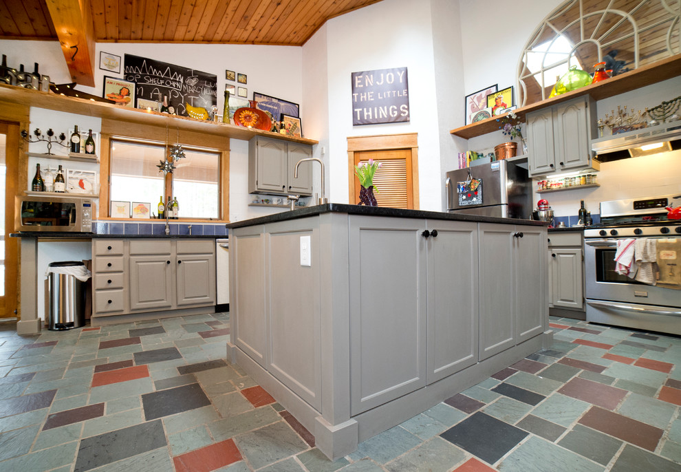 Exempel på ett avskilt, stort klassiskt l-kök, med en undermonterad diskho, luckor med upphöjd panel, grå skåp, granitbänkskiva, blått stänkskydd, stänkskydd i keramik, rostfria vitvaror, skiffergolv, en köksö och flerfärgat golv