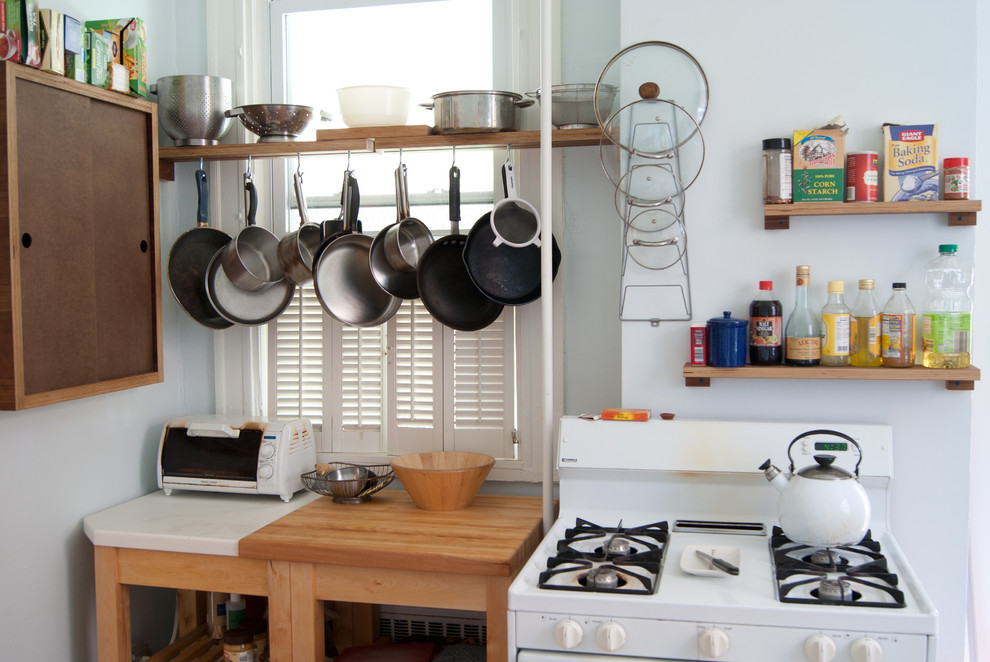На фото: кухня в стиле фьюжн с белой техникой и деревянной столешницей