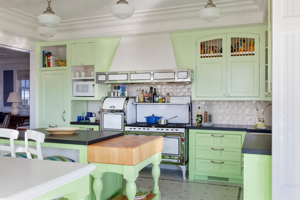 Example of a large beach style u-shaped linoleum floor and gray floor enclosed kitchen design in Boston with shaker cabinets, green cabinets, beige backsplash, subway tile backsplash, white appliances, an island and solid surface countertops