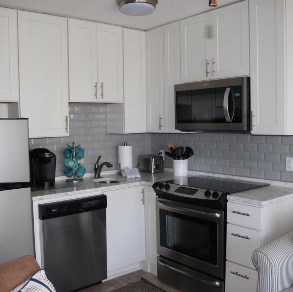Example of a small trendy l-shaped porcelain tile and gray floor eat-in kitchen design in Charleston with a single-bowl sink, flat-panel cabinets, white cabinets, quartzite countertops, gray backsplash, subway tile backsplash, stainless steel appliances, no island and white countertops