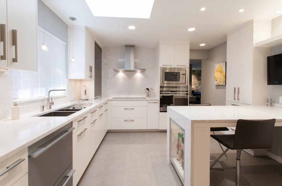Moderne Küche mit Doppelwaschbecken, flächenbündigen Schrankfronten, weißen Schränken, Küchenrückwand in Weiß und Küchengeräten aus Edelstahl in Vancouver