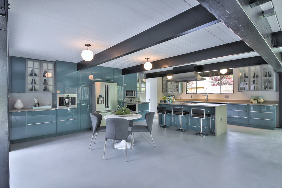 Пример оригинального дизайна: большая угловая кухня в стиле ретро с обеденным столом, врезной мойкой, плоскими фасадами, синими фасадами, столешницей из кварцевого агломерата, техникой из нержавеющей стали, бетонным полом, островом и серым полом