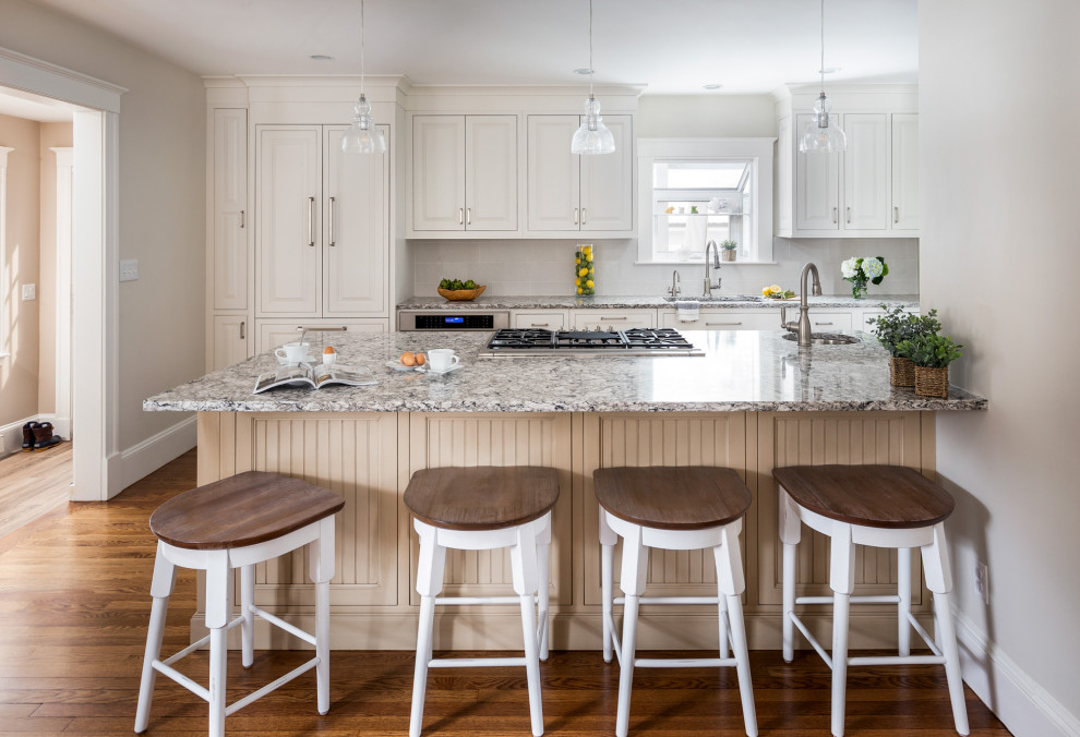 Inspiration for a mid-sized transitional galley medium tone wood floor and brown floor eat-in kitchen remodel in Boston with an undermount sink, beaded inset cabinets, beige cabinets, quartz countertops, white backsplash, ceramic backsplash, paneled appliances, an island and multicolored countertops