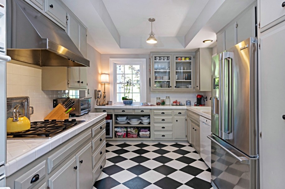 Bild på ett stort vintage kök, med en nedsänkt diskho, luckor med upphöjd panel, grå skåp, kaklad bänkskiva, vitt stänkskydd, stänkskydd i terrakottakakel och rostfria vitvaror