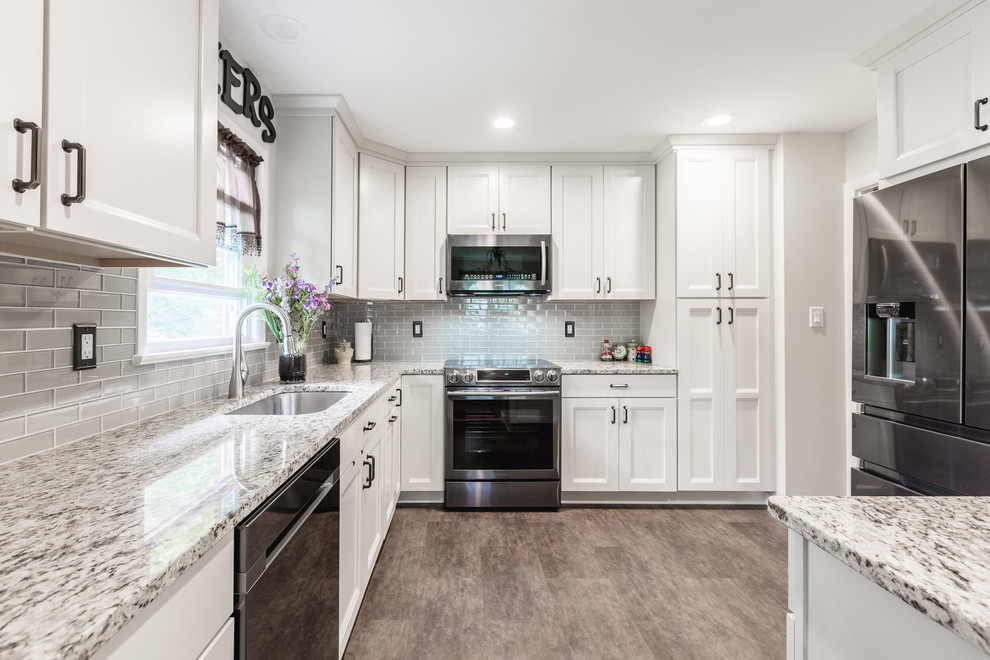 Eat-in kitchen - mid-sized traditional u-shaped brown floor and medium tone wood floor eat-in kitchen idea in DC Metro with an island, an undermount sink, shaker cabinets, white cabinets, gray countertops, stainless steel appliances, granite countertops, gray backsplash and subway tile backsplash