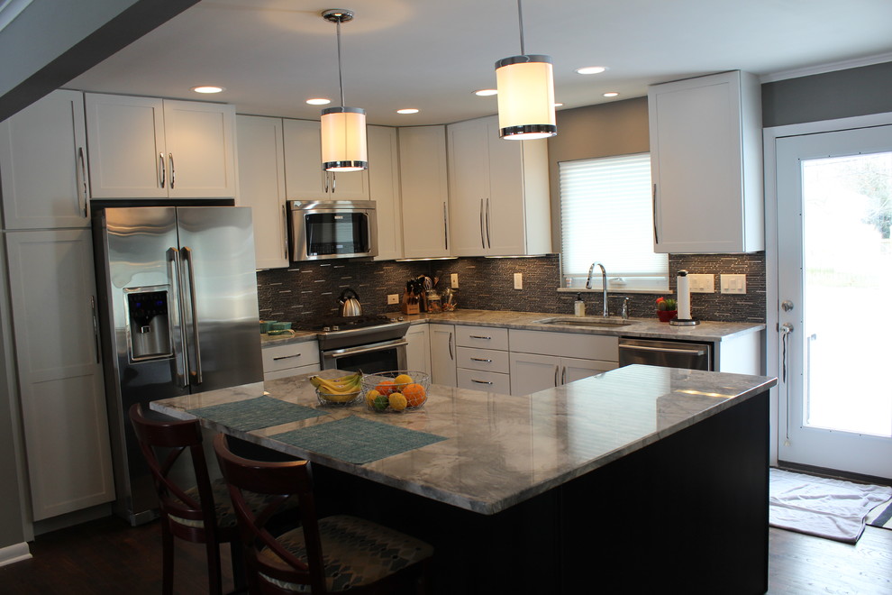 Bild på ett mellanstort funkis kök, med en undermonterad diskho, skåp i shakerstil, vita skåp, marmorbänkskiva, grått stänkskydd, rostfria vitvaror, mörkt trägolv och en köksö