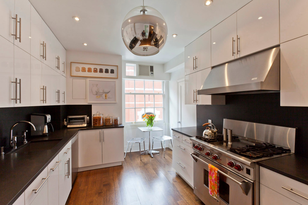 На фото: кухня в стиле модернизм с техникой из нержавеющей стали и черно-белыми фасадами