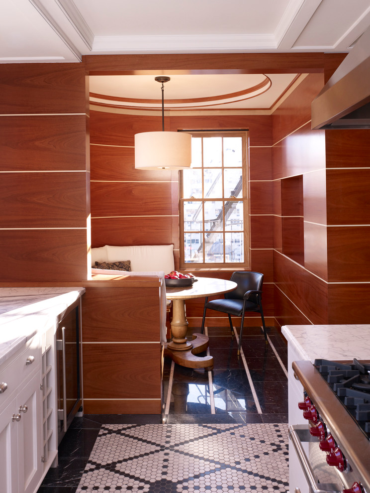 Bild på ett vintage kök och matrum, med luckor med infälld panel, vita skåp och marmorbänkskiva