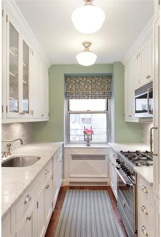 Small transitional galley medium tone wood floor enclosed kitchen photo in New York with a single-bowl sink, flat-panel cabinets, white cabinets, marble countertops, gray backsplash, ceramic backsplash, stainless steel appliances and no island