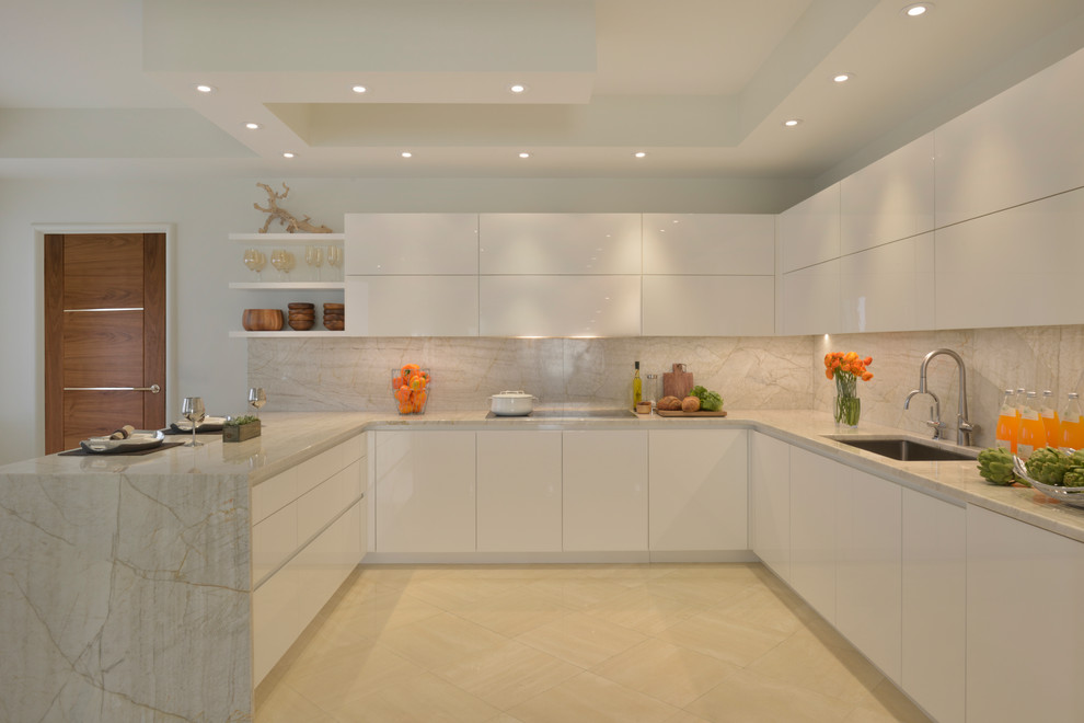 ニューヨークにある広いコンテンポラリースタイルのおしゃれなキッチン (アンダーカウンターシンク、フラットパネル扉のキャビネット、白いキャビネット、大理石カウンター、ベージュキッチンパネル、白い調理設備、大理石の床) の写真