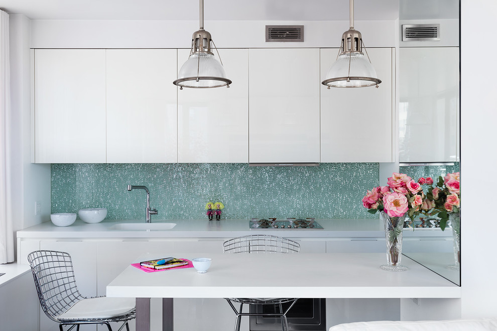 Small trendy single-wall eat-in kitchen photo in New York with white cabinets, blue backsplash, a peninsula, white countertops, an integrated sink and flat-panel cabinets