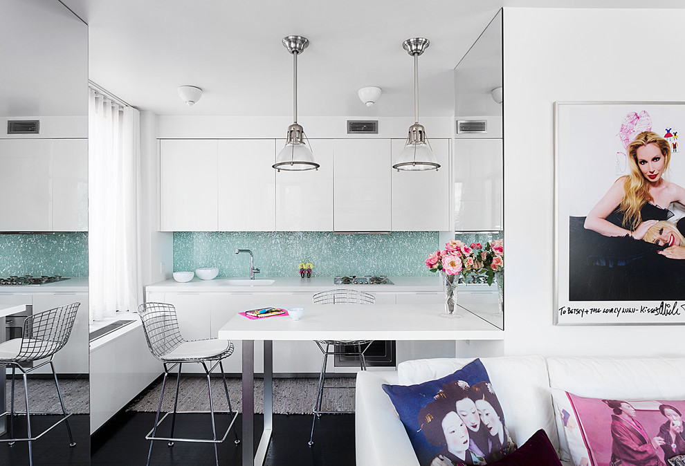 Small contemporary kitchen/diner in New York with white cabinets, blue splashback, a breakfast bar and white worktops.