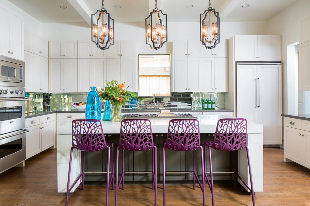 Photo of a large traditional grey and purple u-shaped open plan kitchen in Denver with a submerged sink, shaker cabinets, white cabinets, engineered stone countertops, metallic splashback, integrated appliances, an island, mirror splashback and dark hardwood flooring.