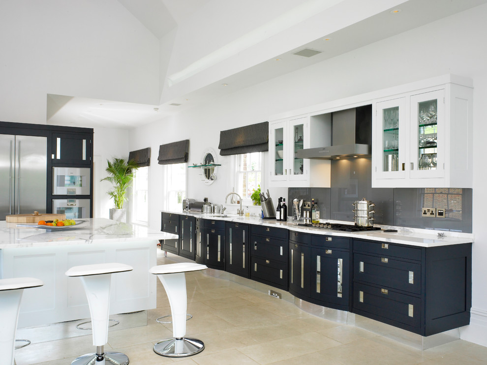 This is an example of an expansive traditional kitchen in London with grey splashback and glass sheet splashback.