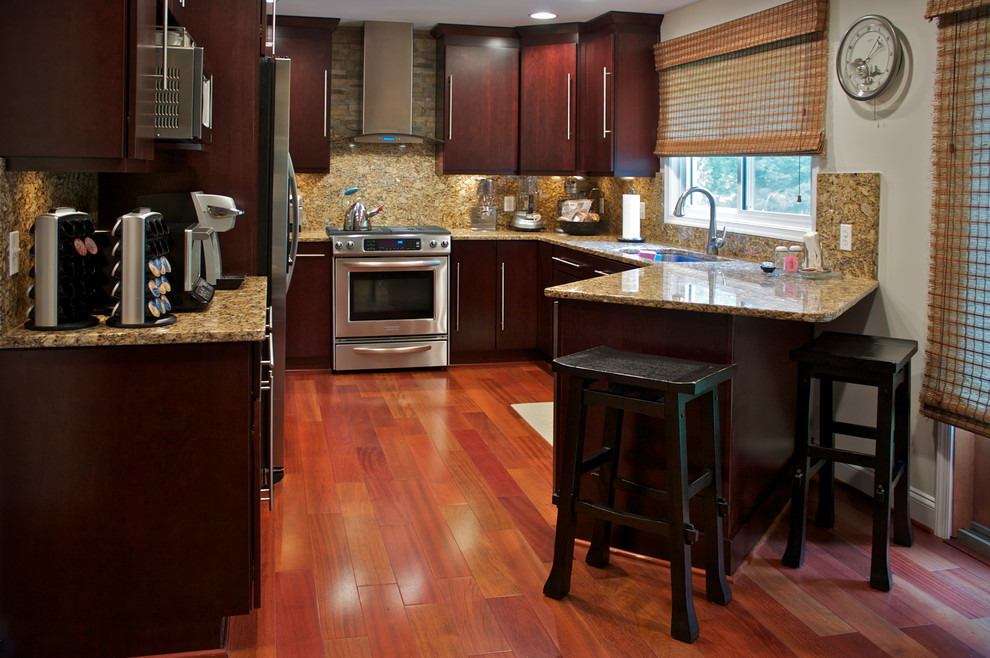 Пример оригинального дизайна: п-образная кухня среднего размера в современном стиле с врезной мойкой, темными деревянными фасадами, гранитной столешницей, коричневым фартуком, техникой из нержавеющей стали и полуостровом