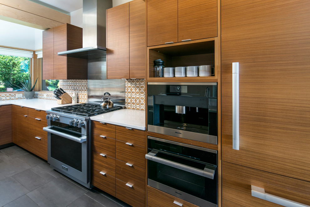 Immagine di una cucina a L design di medie dimensioni con ante lisce, ante in legno scuro, paraspruzzi multicolore, elettrodomestici in acciaio inossidabile, pavimento grigio e top bianco