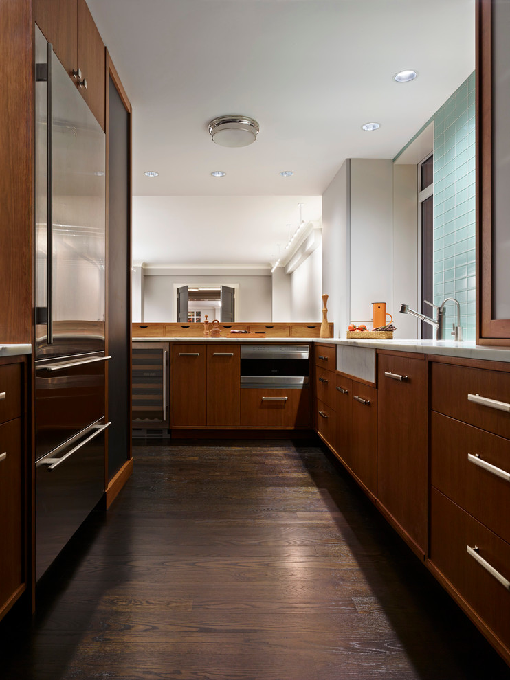 Example of a mid-sized trendy u-shaped dark wood floor and brown floor open concept kitchen design in New York with flat-panel cabinets, medium tone wood cabinets, marble countertops, green backsplash, glass tile backsplash, stainless steel appliances, an undermount sink and no island