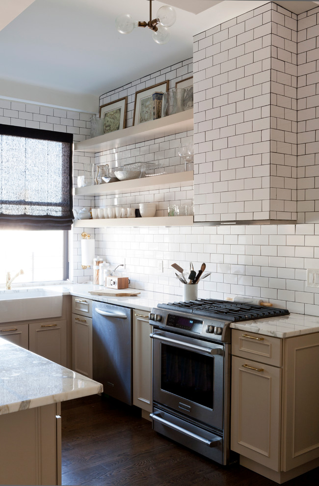 Transitional u-shaped eat-in kitchen photo in New York with a farmhouse sink, marble countertops, white backsplash, stainless steel appliances, beige cabinets, subway tile backsplash and raised-panel cabinets