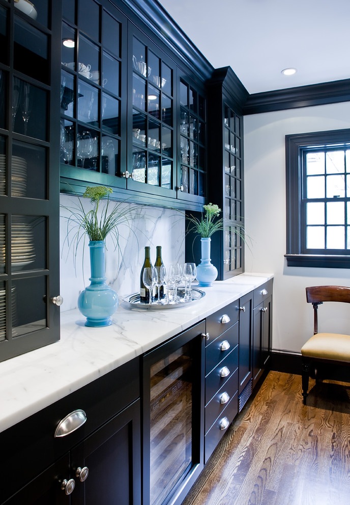 На фото: кухня в классическом стиле с стеклянными фасадами, черными фасадами, мраморной столешницей, белым фартуком и фартуком из каменной плиты с