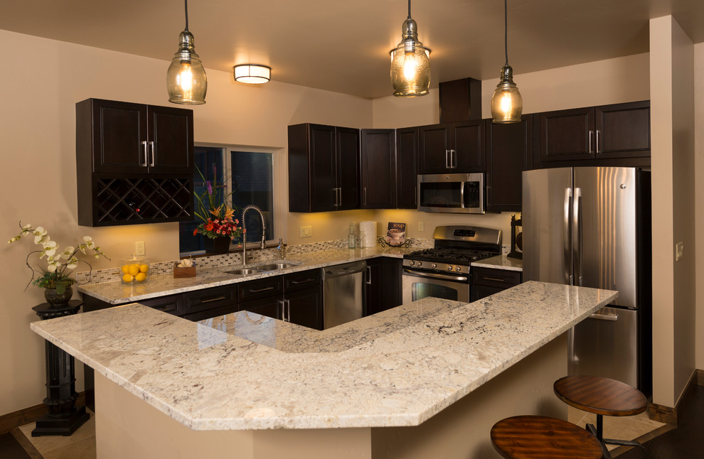 Example of a small trendy l-shaped travertine floor eat-in kitchen design in Denver with an undermount sink, shaker cabinets, dark wood cabinets, granite countertops, metallic backsplash, ceramic backsplash, stainless steel appliances and an island
