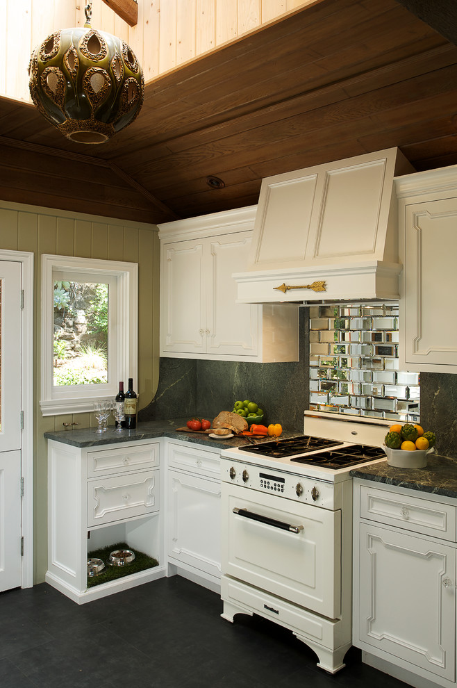 Mountain style kitchen photo in Los Angeles with recessed-panel cabinets, mirror backsplash, white appliances and white cabinets