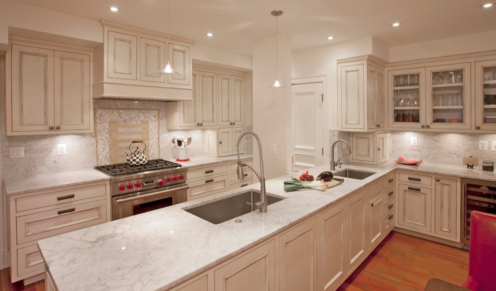 ワシントンD.C.にあるトラディショナルスタイルのおしゃれなキッチン (アンダーカウンターシンク、落し込みパネル扉のキャビネット、ベージュのキャビネット、白いキッチンパネル、シルバーの調理設備) の写真