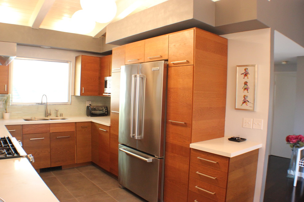 Example of a 1960s u-shaped eat-in kitchen design in Los Angeles with an undermount sink, flat-panel cabinets, medium tone wood cabinets, quartzite countertops, white backsplash and stainless steel appliances