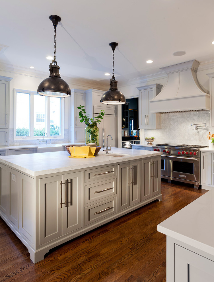 Inspiration for a timeless u-shaped kitchen remodel in Charlotte with gray cabinets, shaker cabinets, white backsplash, stone tile backsplash, a farmhouse sink and stainless steel appliances