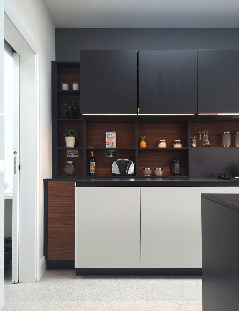 Design ideas for a contemporary enclosed kitchen in Dublin with flat-panel cabinets, grey cabinets, laminate countertops, grey splashback, black appliances, lino flooring and an island.