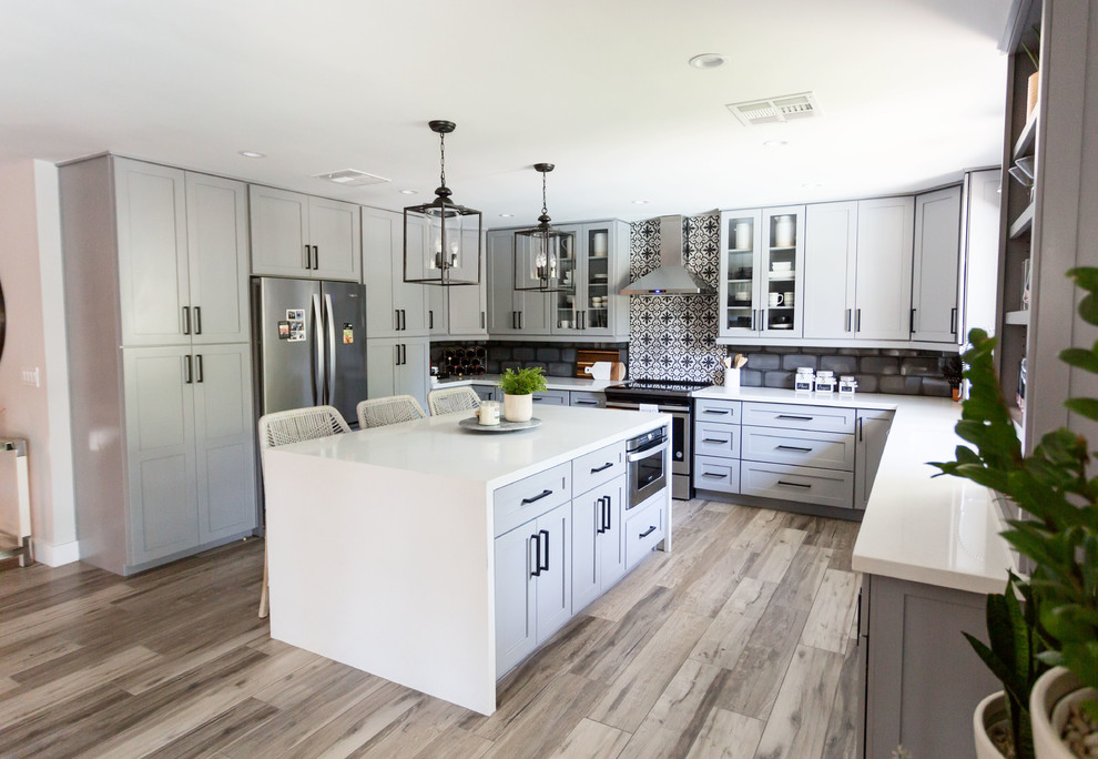 Eat-in kitchen - mid-sized transitional u-shaped light wood floor and gray floor eat-in kitchen idea in Phoenix with an undermount sink, recessed-panel cabinets, gray cabinets, quartz countertops, multicolored backsplash, ceramic backsplash, stainless steel appliances, an island and white countertops