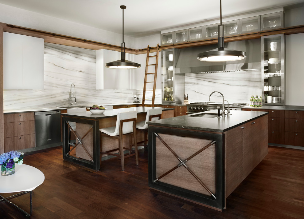 Immagine di una cucina design con lavello sottopiano, ante di vetro, paraspruzzi bianco e elettrodomestici in acciaio inossidabile