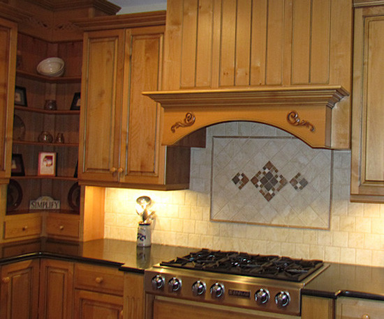 Foto på ett avskilt, mellanstort amerikanskt l-kök, med skåp i shakerstil, skåp i ljust trä, bänkskiva i kvarts, beige stänkskydd, stänkskydd i travertin och rostfria vitvaror