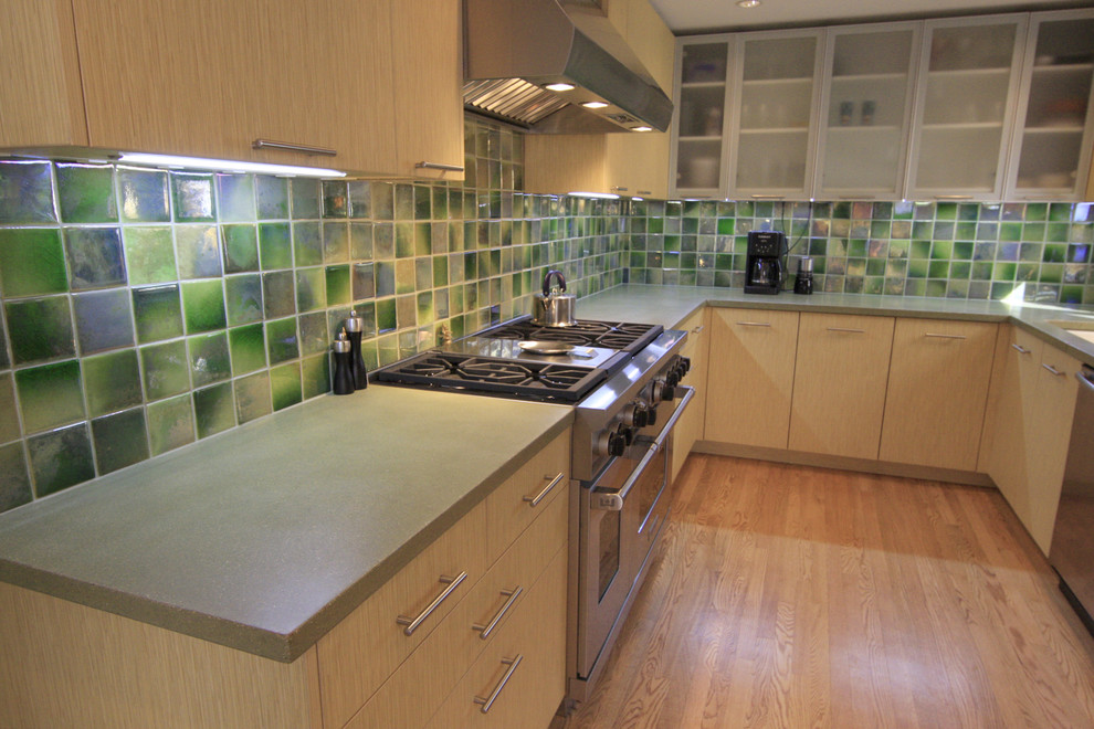 Contemporary kitchen in Other with green splashback and stainless steel appliances.