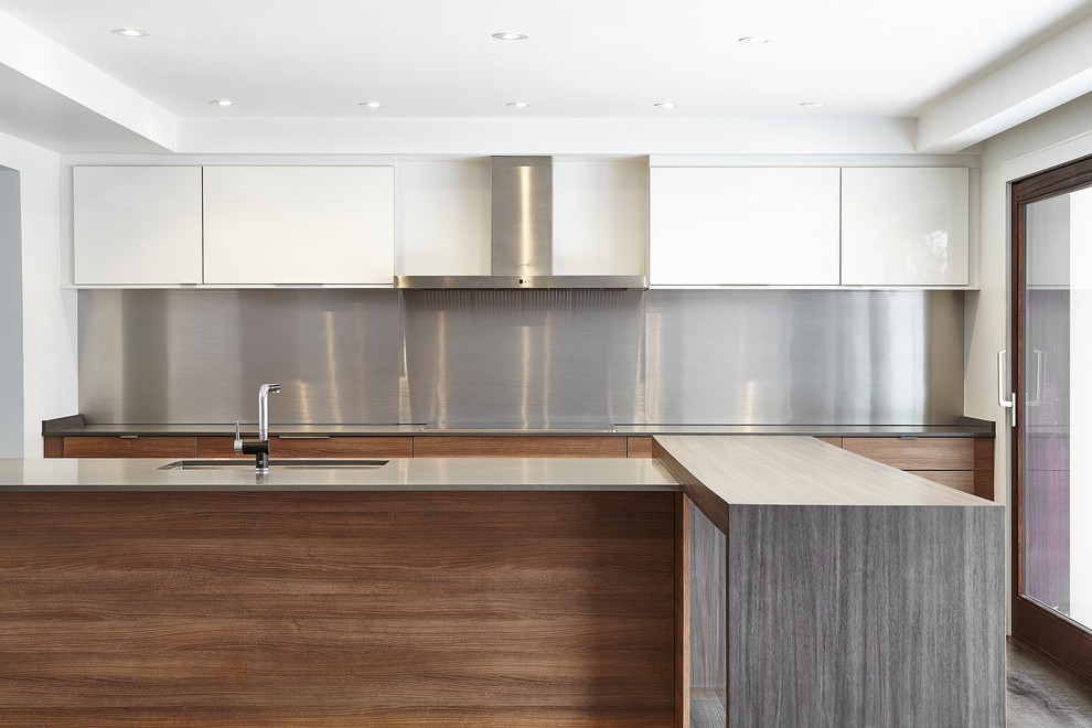 Exempel på ett retro kök, med en undermonterad diskho, släta luckor, skåp i mellenmörkt trä, bänkskiva i kvarts, stänkskydd med metallisk yta, stänkskydd i metallkakel, integrerade vitvaror, vinylgolv och en halv köksö