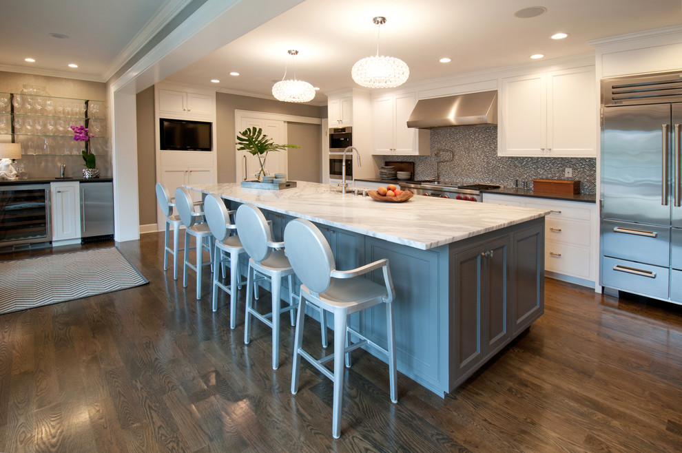 Exempel på ett stort klassiskt kök, med en enkel diskho, luckor med infälld panel, vita skåp, marmorbänkskiva, stänkskydd i sten, rostfria vitvaror, ljust trägolv, en köksö och flerfärgad stänkskydd