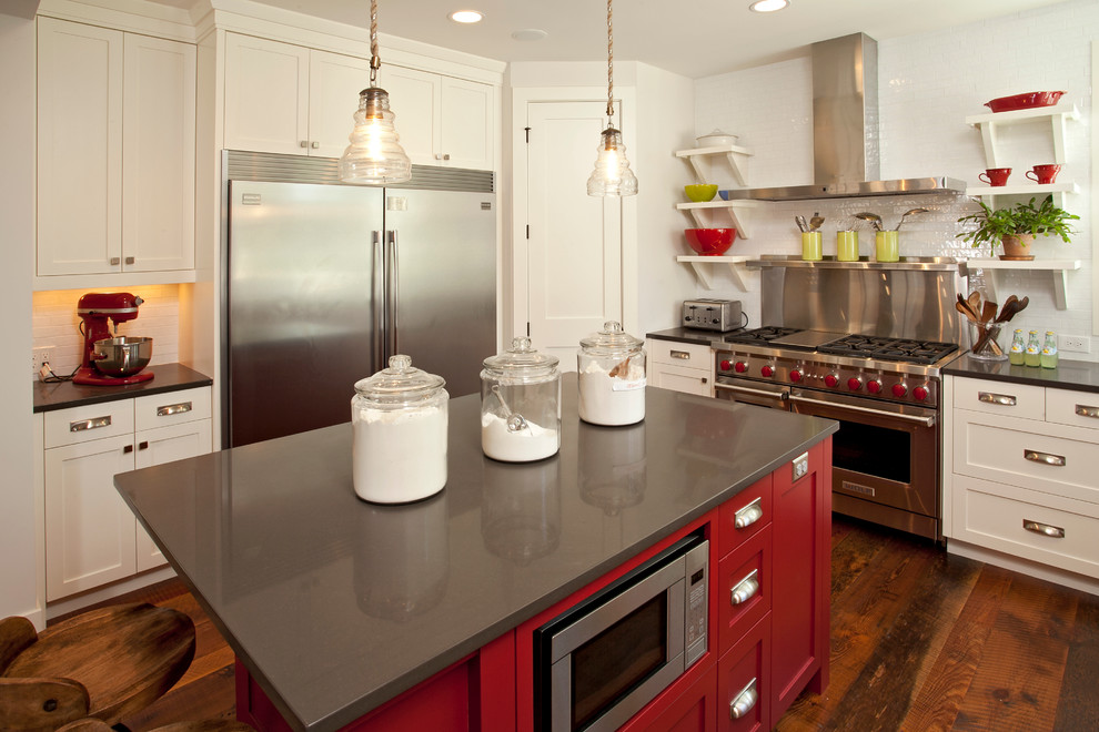 Modelo de cocina campestre con puertas de armario blancas, salpicadero blanco, salpicadero de azulejos tipo metro y electrodomésticos de acero inoxidable