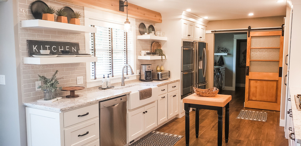 Eat-in kitchen - large farmhouse galley ceramic tile and brown floor eat-in kitchen idea in Other with a farmhouse sink, shaker cabinets, white cabinets, gray backsplash, subway tile backsplash, stainless steel appliances, an island and white countertops