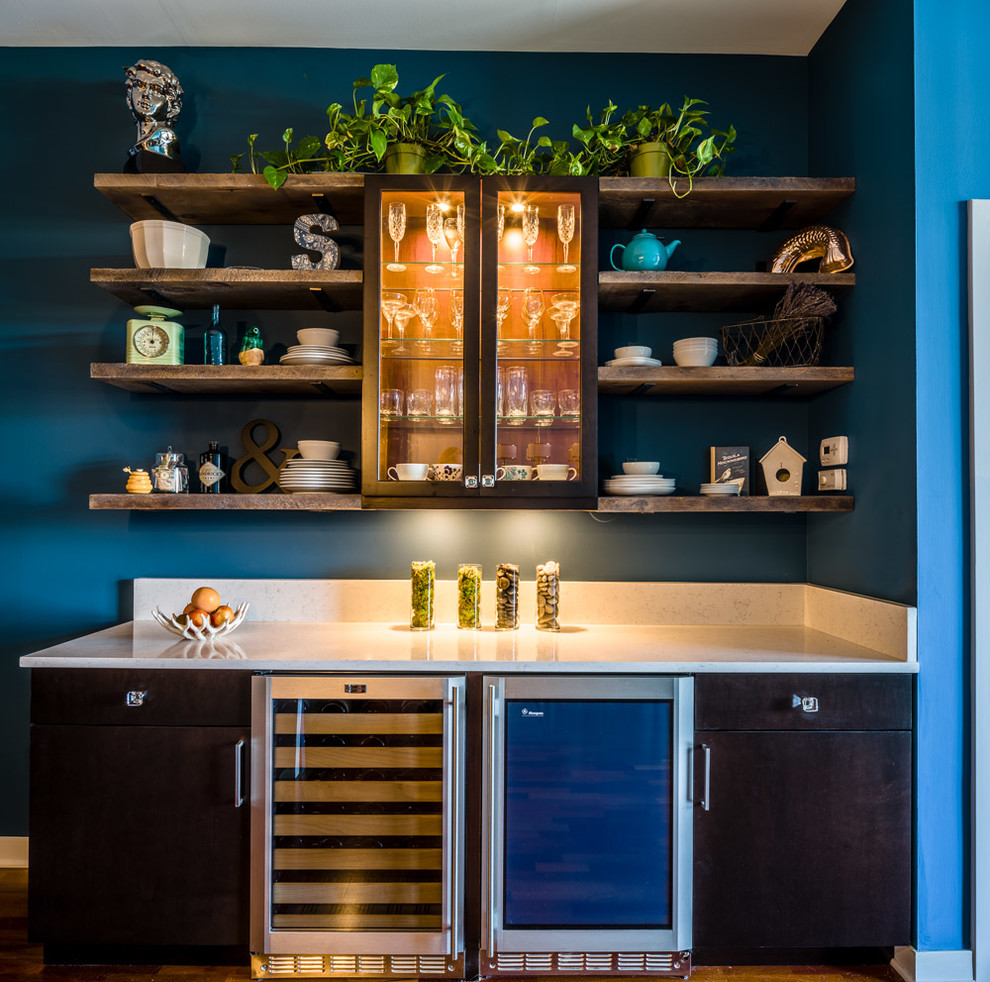 Foto på ett litet funkis kök, med en dubbel diskho, släta luckor, bruna skåp, bänkskiva i kvarts, blått stänkskydd, stänkskydd i glaskakel, rostfria vitvaror, mellanmörkt trägolv och en halv köksö