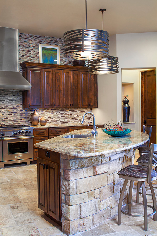Cette image montre une grande cuisine américaine design en L et bois foncé avec un placard avec porte à panneau surélevé, un plan de travail en granite et îlot.