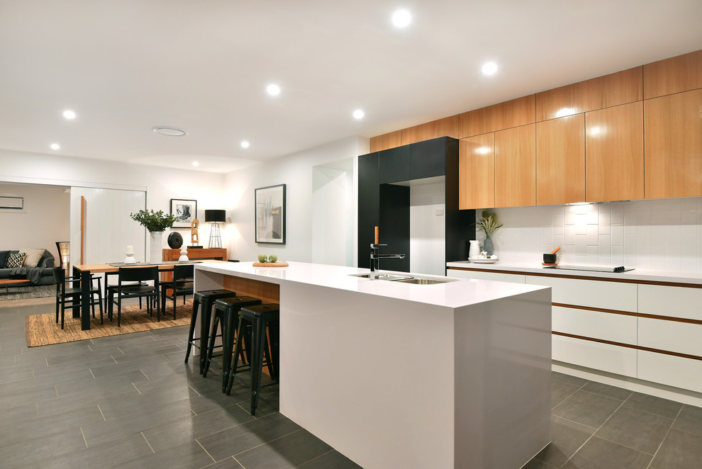 Example of a mid-sized trendy ceramic tile and black floor eat-in kitchen design in Other with a double-bowl sink, flat-panel cabinets, white backsplash, ceramic backsplash and white countertops