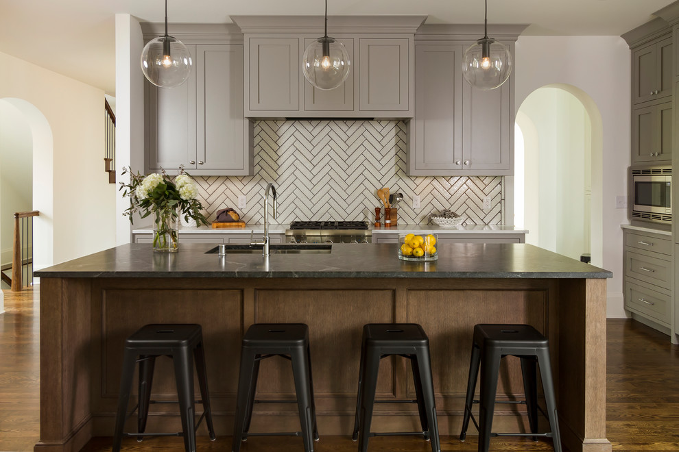 Inspiration for a large transitional dark wood floor and brown floor kitchen remodel in Minneapolis with an undermount sink, shaker cabinets, an island, gray cabinets, white backsplash, stainless steel appliances and granite countertops