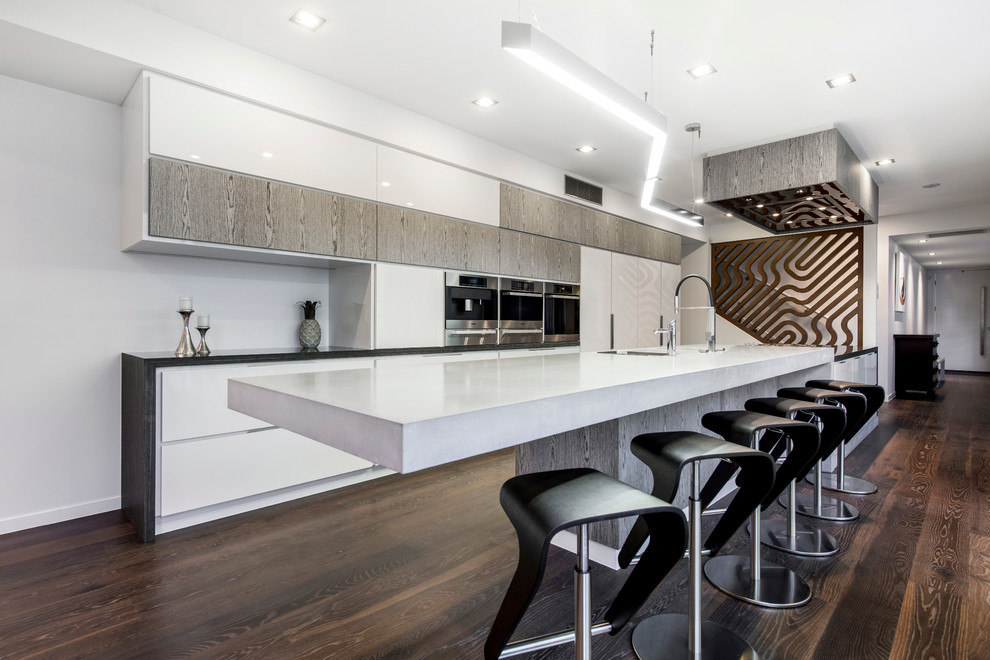 Zweizeilige, Mittelgroße Moderne Wohnküche mit Unterbauwaschbecken, flächenbündigen Schrankfronten, Küchengeräten aus Edelstahl, dunklem Holzboden und Kücheninsel in Brisbane