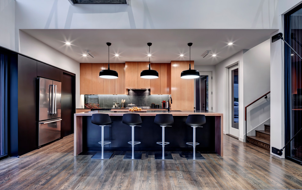 Inspiration for a modern l-shaped medium tone wood floor and brown floor eat-in kitchen remodel in Dallas with an undermount sink, flat-panel cabinets, light wood cabinets, quartz countertops, black backsplash, porcelain backsplash, black appliances, an island and black countertops