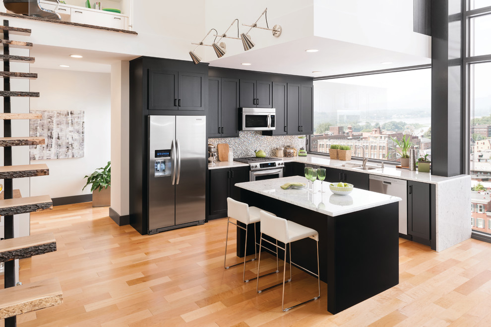 Moderne Küche in L-Form mit Doppelwaschbecken, Schrankfronten im Shaker-Stil, bunter Rückwand, Rückwand aus Mosaikfliesen, Küchengeräten aus Edelstahl, hellem Holzboden und Kücheninsel in Minneapolis