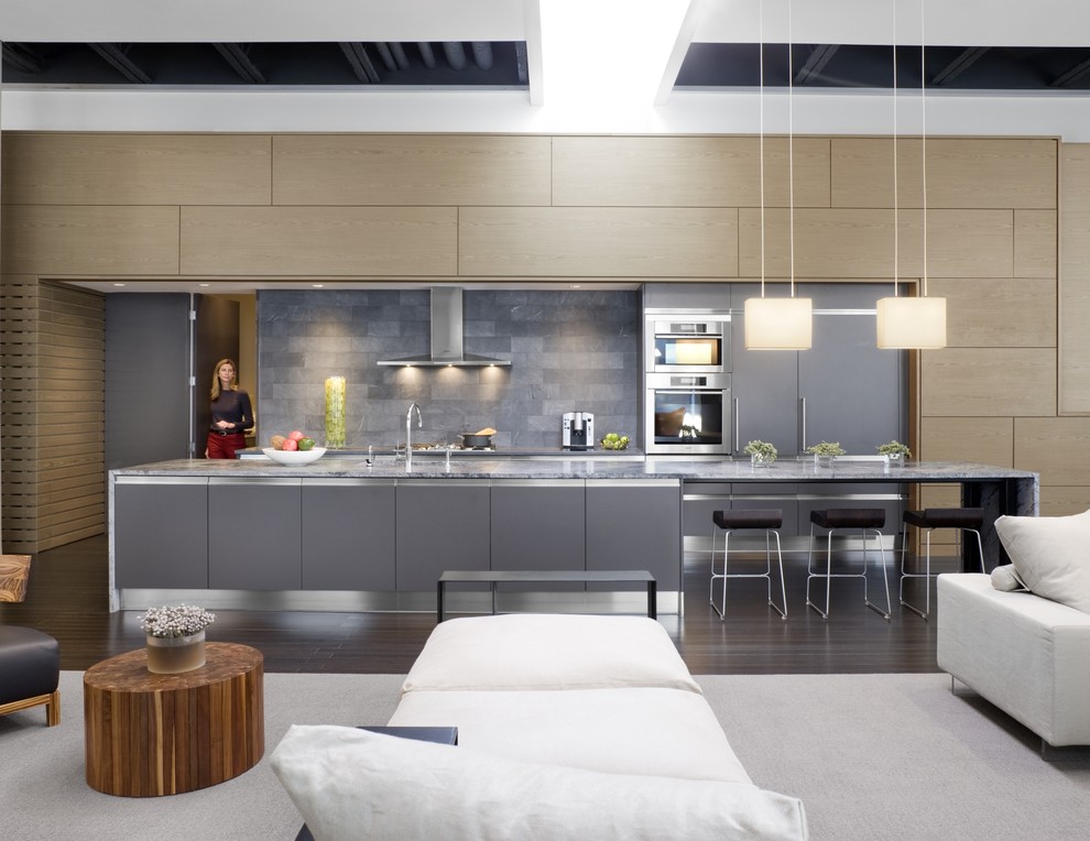 Esempio di una cucina contemporanea con ante lisce, ante grigie, paraspruzzi grigio, elettrodomestici in acciaio inossidabile, parquet scuro, pavimento marrone e top grigio
