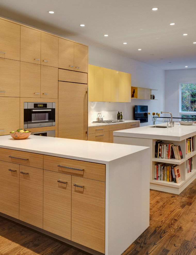 Immagine di una cucina di medie dimensioni con lavello sottopiano, ante lisce, top in quarzo composito, paraspruzzi bianco, elettrodomestici da incasso e pavimento in legno massello medio
