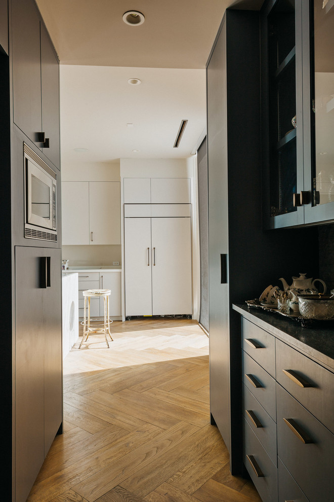 Idee per un cucina con isola centrale contemporaneo con ante lisce, ante bianche, top in quarzite, pavimento in legno massello medio e pavimento marrone