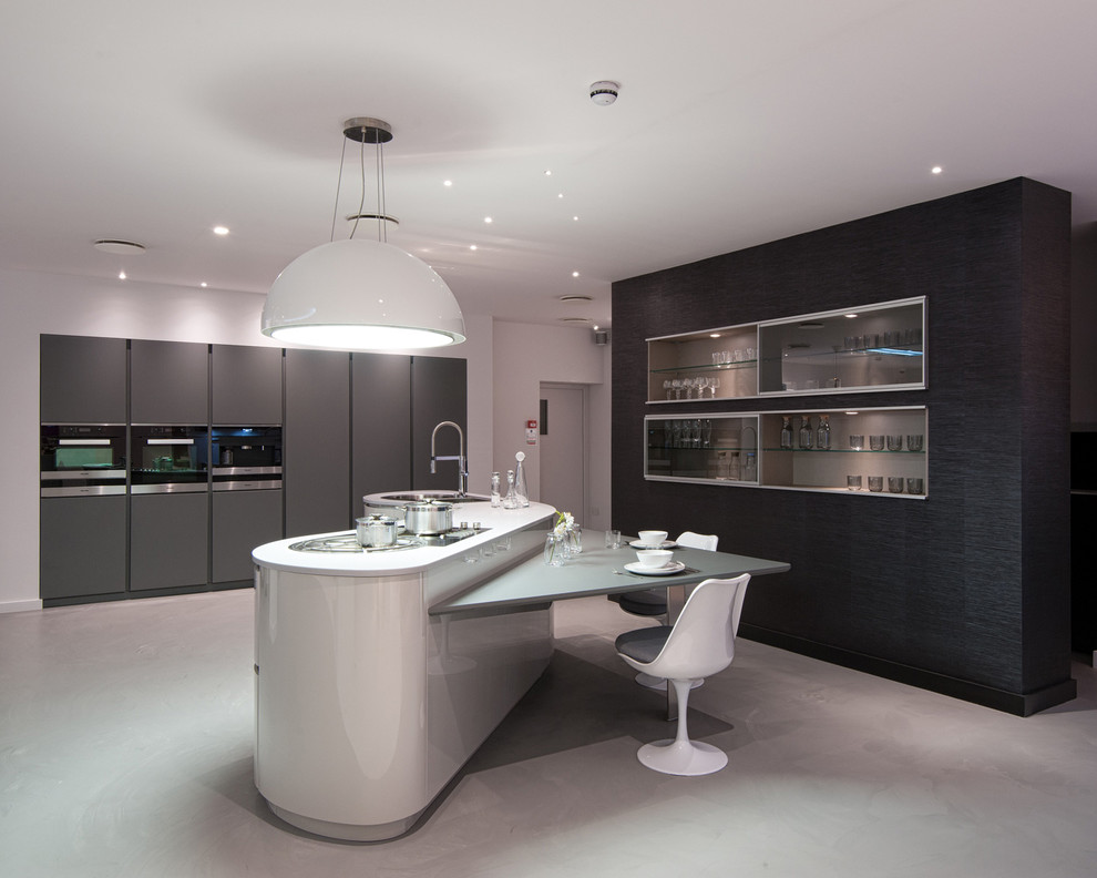 Große Moderne Küche mit Kücheninsel, Unterbauwaschbecken, flächenbündigen Schrankfronten, grauen Schränken und Betonboden in London