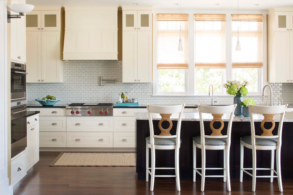 デンバーにあるトランジショナルスタイルのおしゃれなキッチン (シルバーの調理設備、シェーカースタイル扉のキャビネット、白いキャビネット、白いキッチンパネル、サブウェイタイルのキッチンパネル) の写真